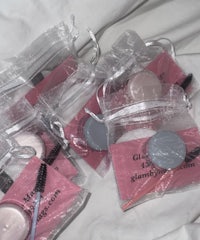 a group of pink makeup bags on a bed